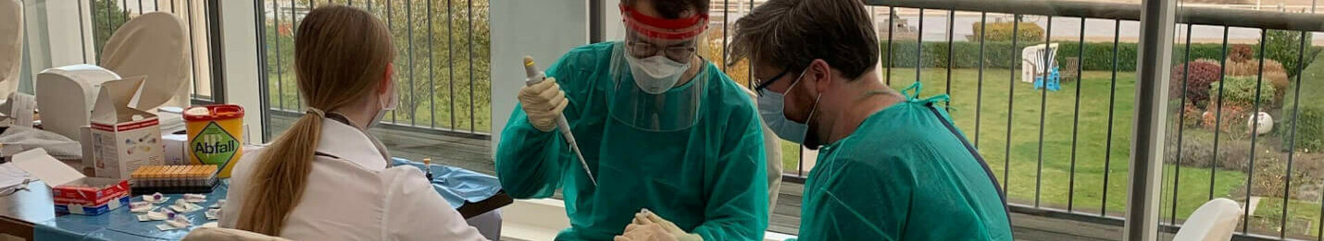 Tourismus Studie - Corona-Testung | ATLANTIC Grand Hotel Travemünde Medizinisches Personal in Schutzkleidung führt Tests in einem Raum mit Meerblick im ATLANTIC Grand Hotel Travemünde durch.