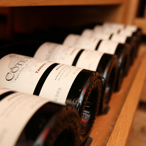 Wine bottles lie on a wooden shelf in the ATLANTIC Hotel Kiel.