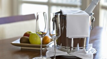 Zwei Sektgläser, Sektflasche im Kühler und Obstteller auf Holztisch. Foto: © Tilo Grellmann - Fotolia.com