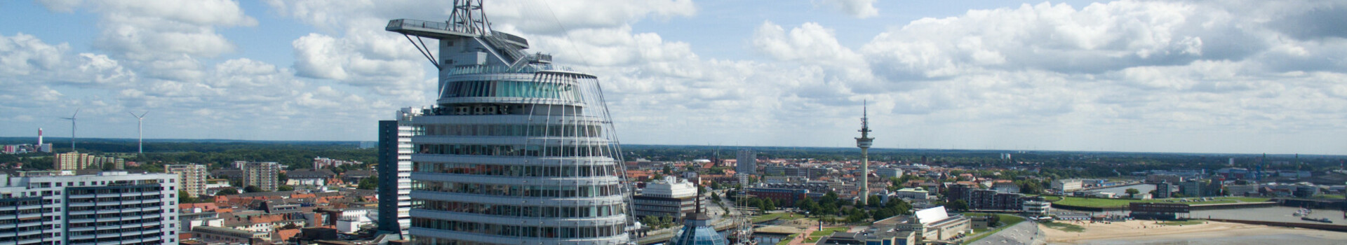 Green Meetings im ATLANTIC Hotel Sail City Bremerhaven ATLANTIC Hotel Sail City in Bremerhaven, modernes Hochhaus am Wasser mit Blick auf die Stadt und die Küste.