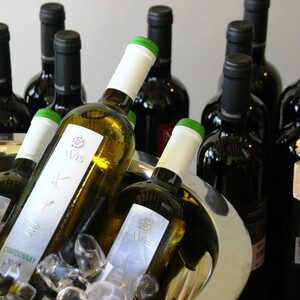 Weinflaschen in einem silbernen Kübel mit Eis, umgeben von weiteren Flaschen.