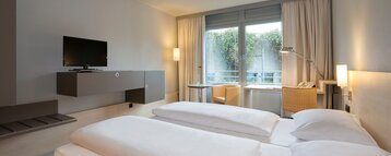 Innenansicht des Economy Zimmers mit Doppelbett und gemütlicher Ausstattung im ATLANTIC Hotel Universum Bremen