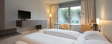 Interior view of a Economy Room with a double bed and cozy furniture in the ATLANTIC Hotel Universum