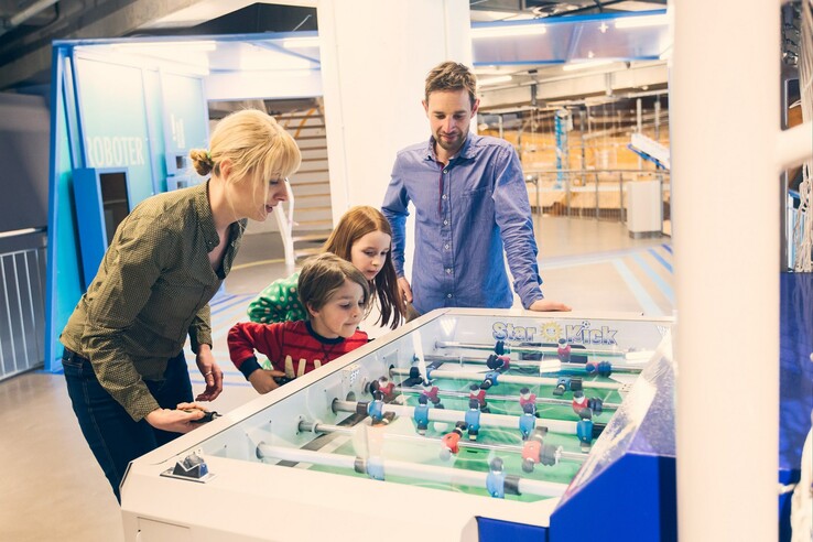 Familie spielt Tischfußball im Universum Bremen, entspannte Atmosphäre und Freizeitspaß.