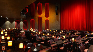 Elegant theater restaurant with red curtains, comfortable seating and subdued lighting at the ATLANTIC Grand Hotel Bremen.