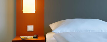 Bett in einem barrierefreien Zimmer | ATLANTIC Hotel Galopprennbahn Bremen
