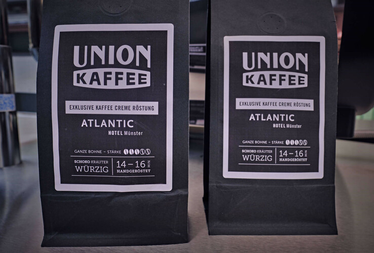 Zwei schwarze Kaffeepackungen der Marke Union Kaffee, speziell für das ATLANTIC Hotel Münster geröstet.