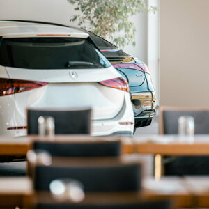 PKW Präsentation im ATLANTIC Hotel Galopprennbahn Zwei Autos parken im Innenbereich des ATLANTIC Hotel Galopprennbahn Bremen, im Vordergrund unscharfe Tische.