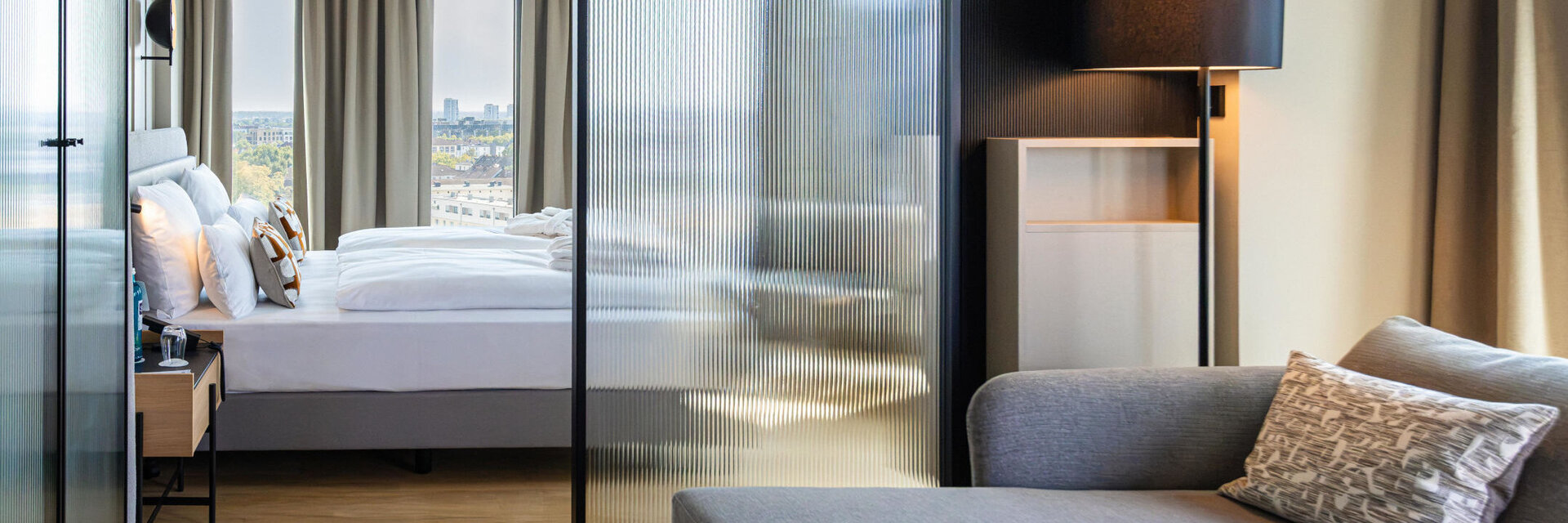 Blick von der Sitzecke auf das Bett und den Ausblick nach draußen.