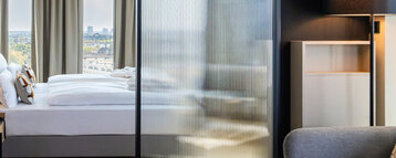 View from the seating area towards the bed and the view outside.