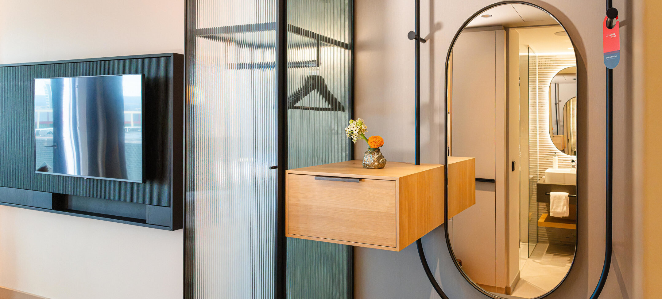 A coat rack and mirror in the entrance area of the room.