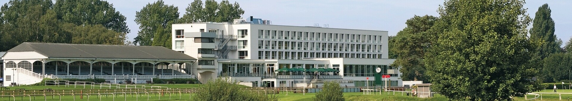 Wiese und Bäume vor dem ATLANTIC Hotel Galopprennbahn in Bremen ATLANTIC Hotel Galopprennbahn Bremen, modern, umgeben von grüner Landschaft und Teich mit Schwänen.