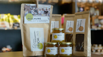 ATLANTIC Hotel Sail City Regio Shop Products Local products at the ATLANTIC Hotel: Weser honey, Deichling blend and Beanbooster coffee on a table.