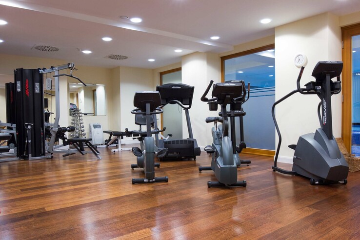 Moderner Fitnessraum mit Cardiogeräten und Kraftstation im ATLANTIC Grand Hotel Travemünde.