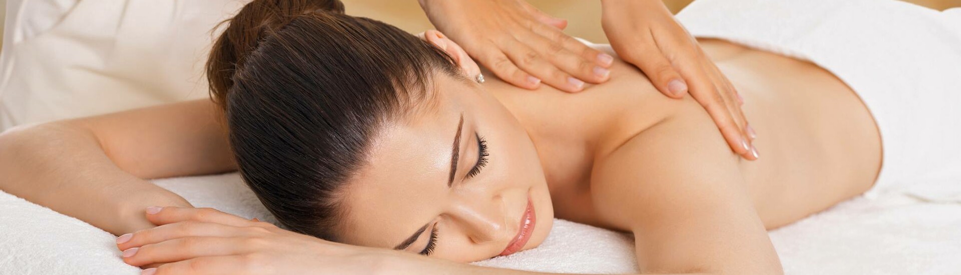 Frau während einer Massage im Wellnessbereich des ATLANTIC Grand Hotel in Bremen Person erhält entspannende Rückenmassage in einem Spa des ATLANTIC Grand Hotel Bremen.