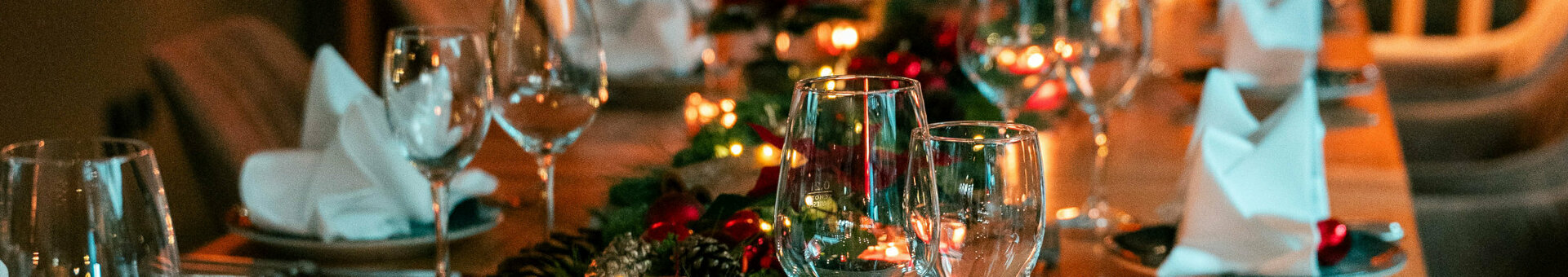 Weihnachtlich gedeckte Tafel mit Tannengrün und Lichterkette