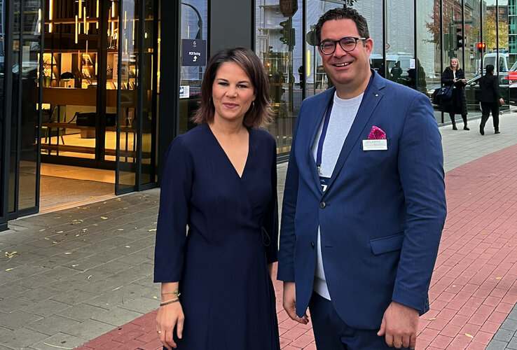 Zwei Personen stehen lächelnd vor dem Eingang des ATLANTIC Hotel Münster.