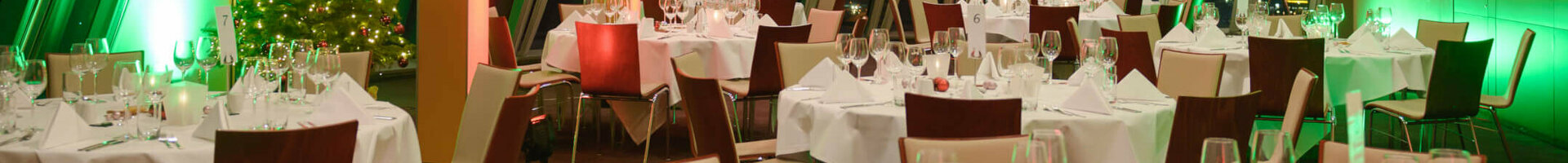 Festively decorated banquet hall in the ATLANTIC Hotel Sail City, Bremerhaven, with Christmas lighting and a decorated tree.