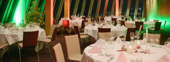 Festlich gedeckter Bankettsaal im ATLANTIC Hotel Sail City, Bremerhaven, mit weihnachtlicher Beleuchtung und geschmücktem Baum.