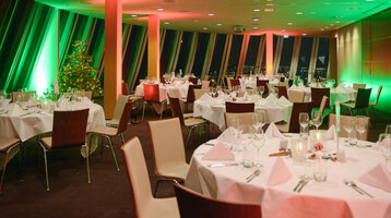 Christmas party in the Captain's Lounge, 19th floor Festively decorated banquet hall in the ATLANTIC Hotel Sail City, Bremerhaven, with Christmas lighting and a decorated tree.