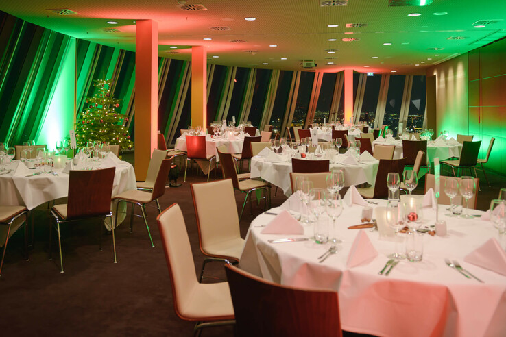 Festively decorated banquet hall in the ATLANTIC Hotel Sail City, Bremerhaven, with Christmas lighting and a decorated tree.