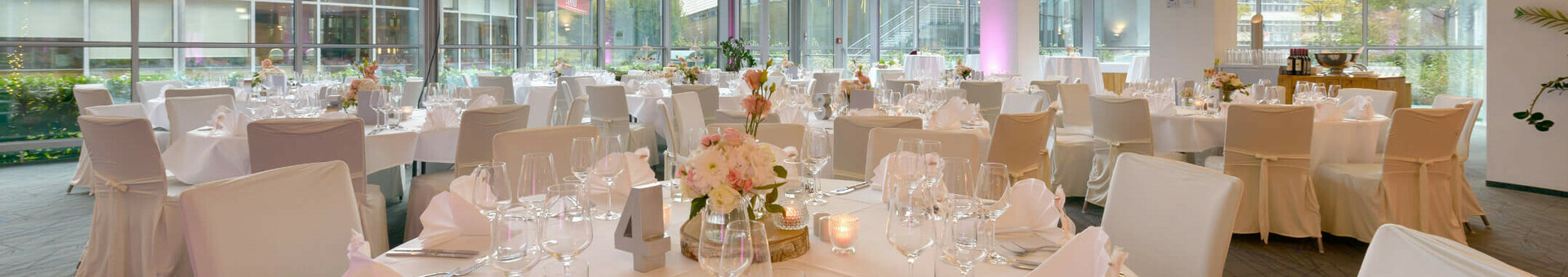 ATLANTIC Hotel Universum – Hochzeit Eleganter Bankettsaal im ATLANTIC Hotel Universum, Bremen, mit gedeckten Tischen und großen Fenstern.