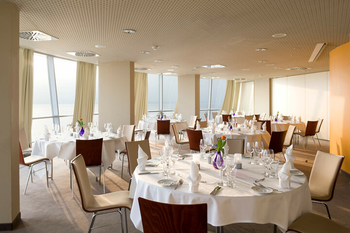 Deck 1 South Bright, elegant banquet hall in the ATLANTIC Hotel Sail City with set tables and panoramic windows.