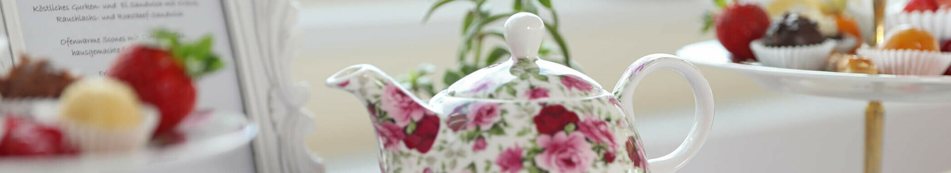 Teekanne mit Gebäck & Petit Fours auf einem Tisch