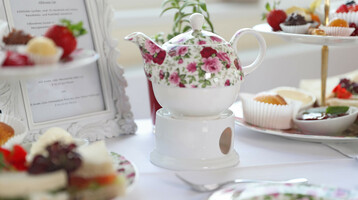 Teekanne mit Gebäck & Petit Fours auf einem Tisch
