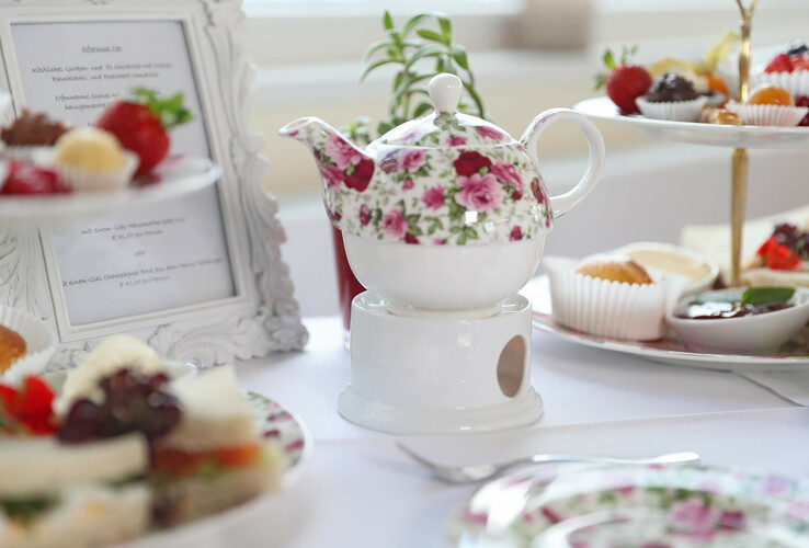 Teekanne mit Gebäck & Petit Fours auf einem Tisch