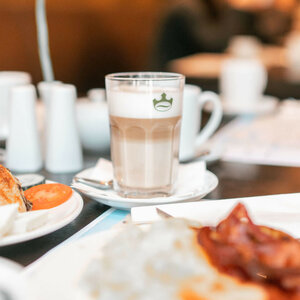 Frühstückstisch im ATLANTIC Hotel Lübeck mit Kaffee, Gebäck und frischen Tomaten.