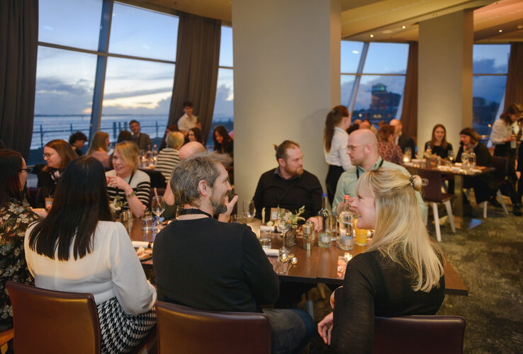 Guests in the restaurant of the ATLANTIC Hotel Sail City enjoying dinner with a sea view.