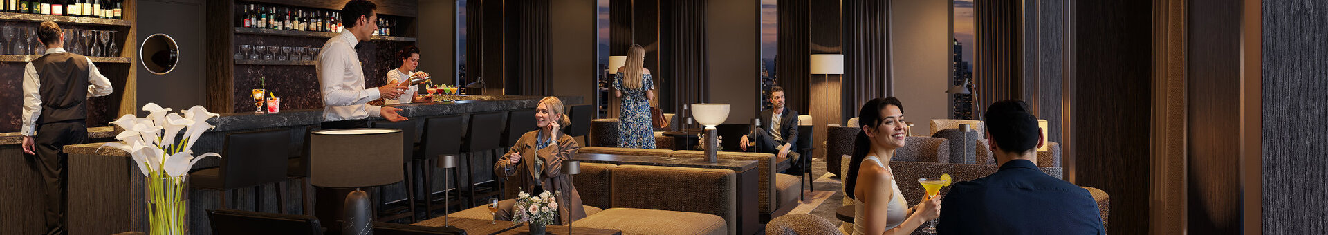 The cosy, modern bar at the ATLANTIC Hotel Frankfurt, featuring indirect ceiling lighting, dark grey walls, a variety of armchairs for seating, and décor in dark wood tones.The cosy, modern bar at the ATLANTIC Hotel Frankfurt, featuring indirect ceiling lighting, dark grey walls, a variety of armchairs for seating, and décor in dark wood tones.