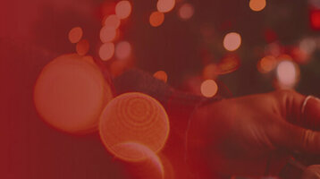 Drei Sektgläser, die angestoßen werden. Auf der linken Hälfte ein roter Farbverlauf.