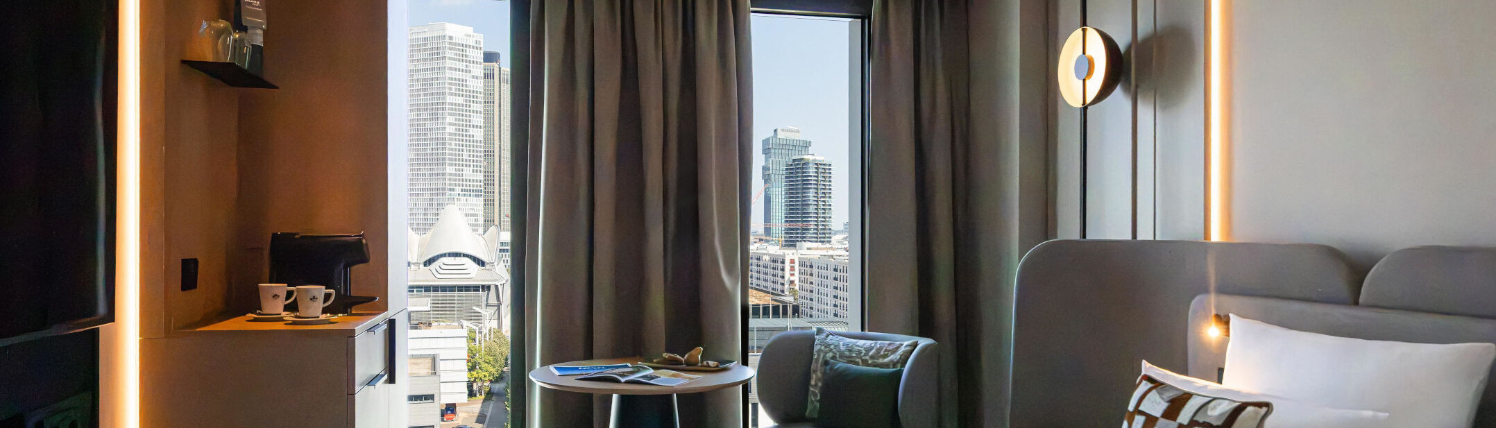 Ausblick auf die Frankfurter Skyline vom Bett im Skyline Zimmer. 