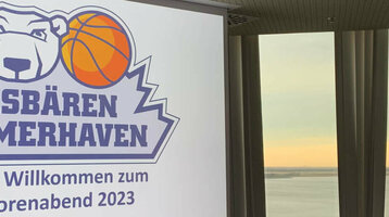 Konferenzraum im ATLANTIC Hotel Sail City mit Blick auf den Sonnenuntergang über dem Wasser, Logo der Eisbären Bremerhaven.