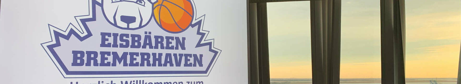 Conference room in the ATLANTIC Hotel Sail City with a view of the sunset over the water, logo of the Bremerhaven polar bears.