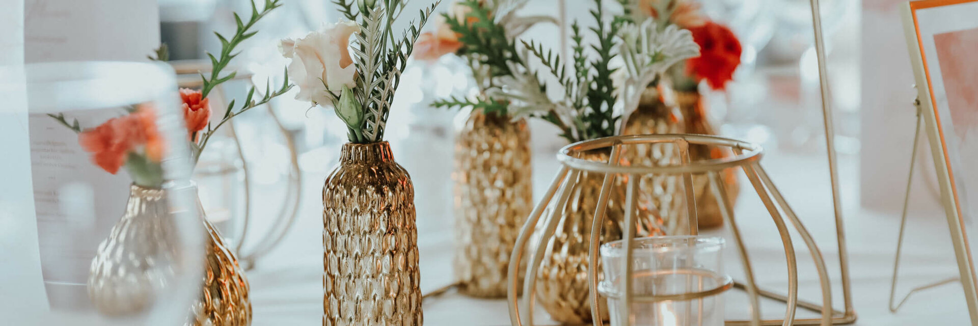 Elegant table decorations with golden vases, flower arrangements and candles at the ATLANTIC Grand Hotel Bremen.