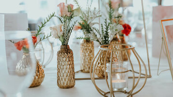 Detailaufnahme einer möglichen Hochzeitsdekoration  Elegante Tischdekoration mit goldenen Vasen, Blumenarrangements und Kerzen im ATLANTIC Grand Hotel Bremen.