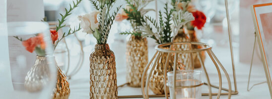 Elegant table decorations with golden vases, flower arrangements and candles at the ATLANTIC Grand Hotel Bremen.