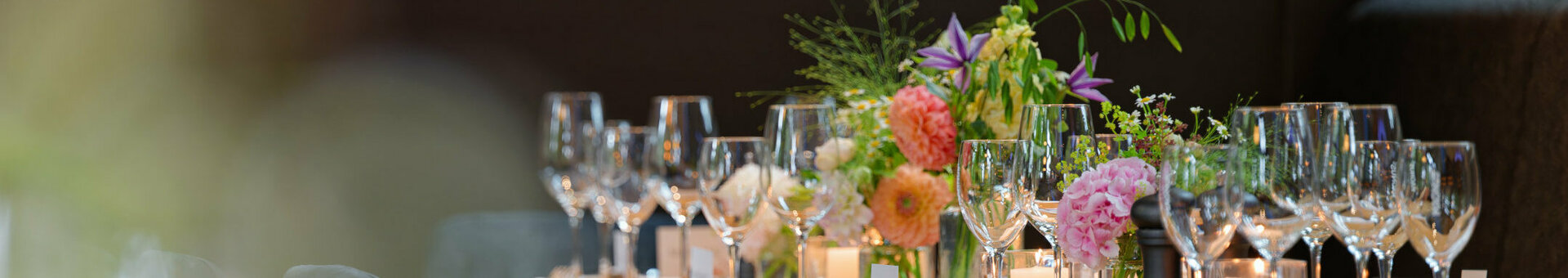 Ein gedeckter Tisch mit Blumensträußen im ATLANTIC Hotel Landgut Horn Wintergarten