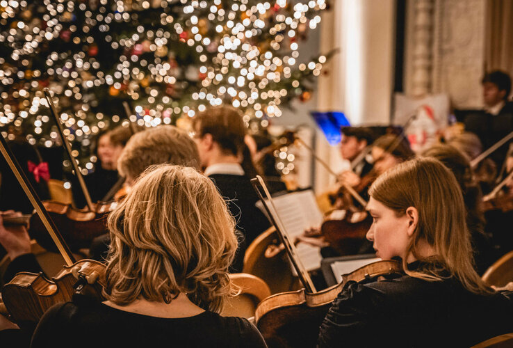 Orchester spielt vor festlich beleuchtetem Weihnachtsbaum im ATLANTIC Grand Hotel Travemünde.