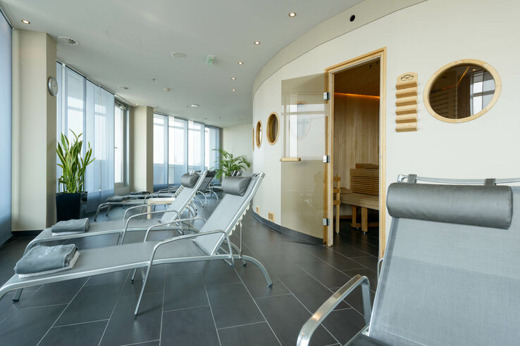 Bright wellness area in the ATLANTIC Hotel Sail City with sun loungers, sauna and large windows.