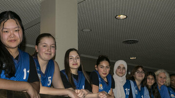 Eine Gruppe junger Frauen in blauen Trikots lehnt an einem Geländer im ATLANTIC Hotel Sail City.