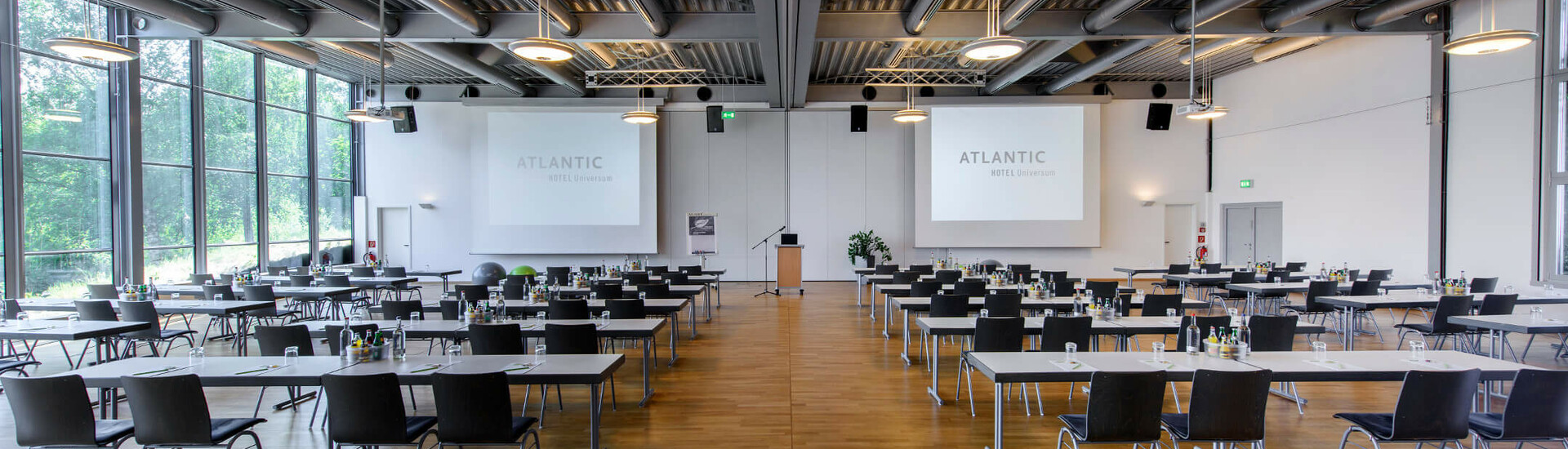 Tagungsraum Saal 1 | Conference Center im ATLANTIC Hotel Universum in Bremen Moderner Konferenzraum im ATLANTIC Hotel Universum mit Tischen, Stühlen und großen Fenstern, die viel Tageslicht hereinlassen.