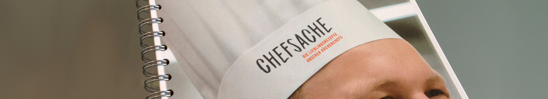 ATLANTIC Hotels Kochbuch "Chefsache" Spiralgebundenes Buch mit Kochmütze auf dem Cover, Aufschrift "Chefsache", von Atlantic Hotels.
