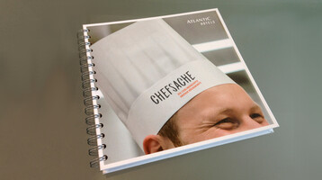 Spiralgebundenes Buch mit Kochmütze auf dem Cover, Aufschrift "Chefsache", von Atlantic Hotels.