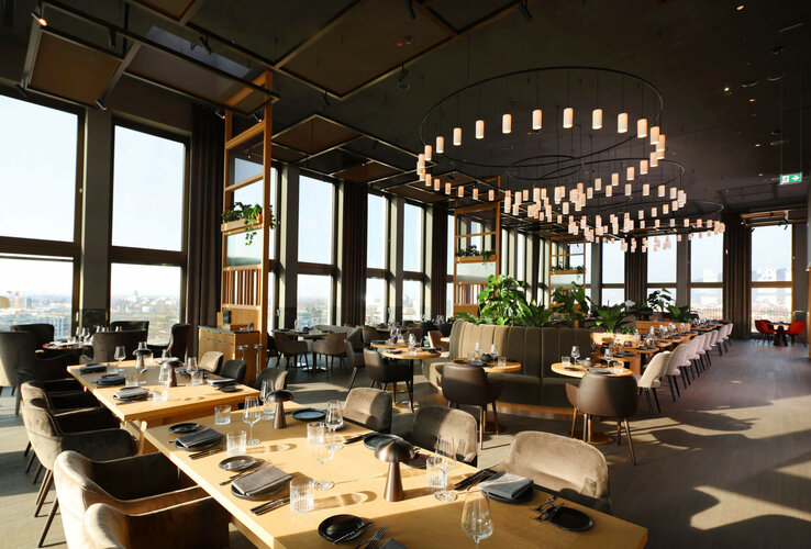 Modern restaurant in the ATLANTIC Hotel Heidelberg with large windows, stylish tables and elegant lighting.