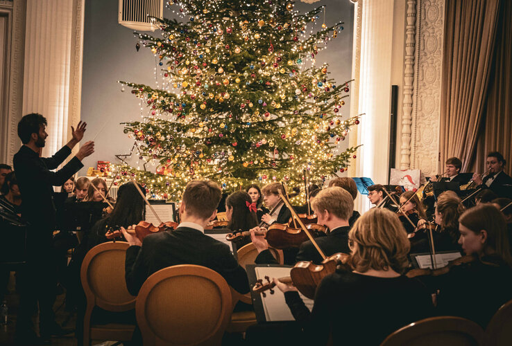 Orchester spielt vor festlich geschmücktem Weihnachtsbaum im ATLANTIC Grand Hotel Travemünde.