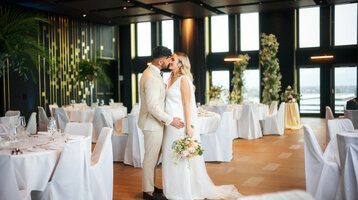 Ein elegantes Hochzeitspaar tanzt in einem stilvollen, festlich dekorierten Raum im ATLANTIC Hotel Heidelberg.